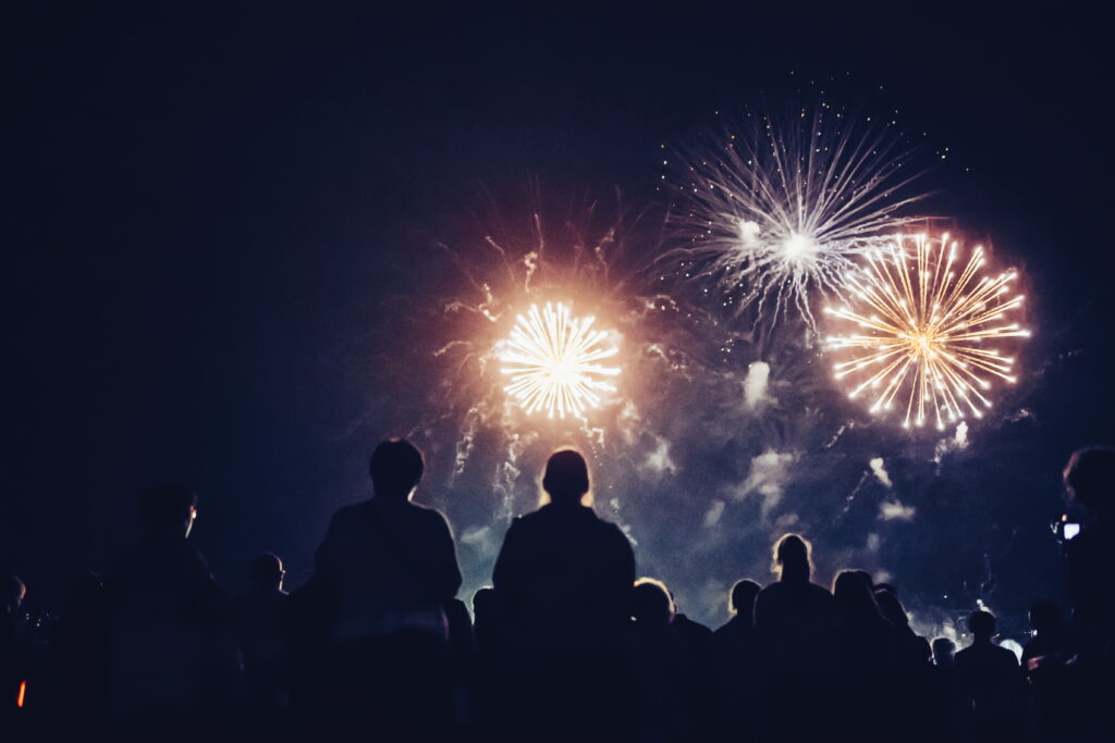 Crowd watching fireworks and celebrating Fourth of July at night