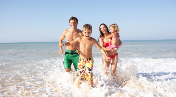 family running in the water at the beach